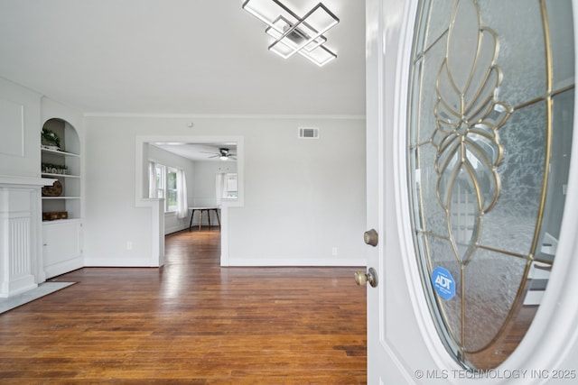 1601 E 6th St, Okmulgee, OK 74447 - entryway featuring wood finished floors, ornamental molding, ceiling fan, and a fireplace with flush hearth