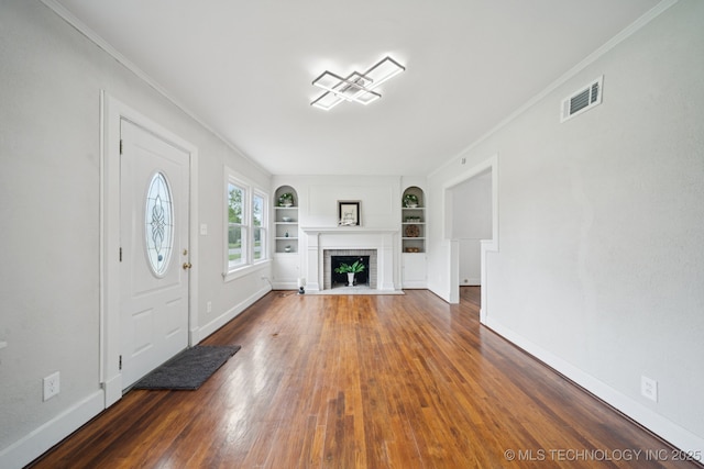 1601 E 6th St, Okmulgee, OK 74447 - entrance foyer featuring a brick fireplace, wood finished floors, and ornamental molding