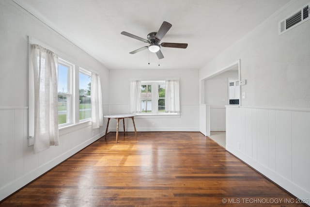 1601 E 6th St, Okmulgee, OK 74447 - empty room with wood finished floors, ceiling fan, and a wainscoted wall