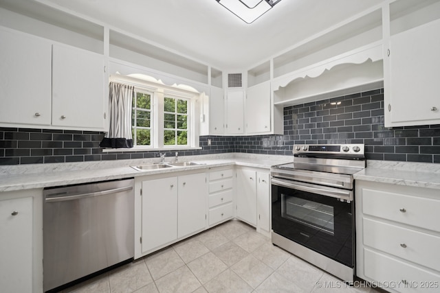 1601 E 6th St, Okmulgee, OK 74447 - kitchen with stainless steel appliances, tasteful backsplash, and light tile patterned flooring
