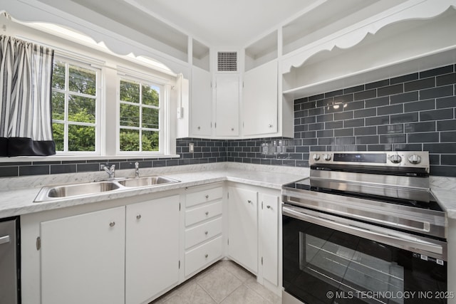 1601 E 6th St, Okmulgee, OK 74447 - kitchen with stainless steel appliances, white cabinetry, light tile patterned flooring, tasteful backsplash, and light stone counters