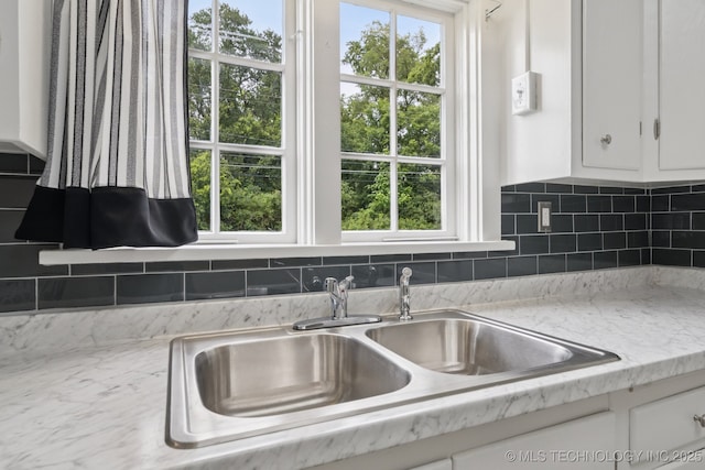 1601 E 6th St, Okmulgee, OK 74447 - kitchen view of white cabinetry, tasteful backsplash, and light countertops
