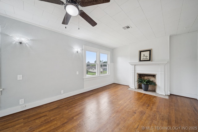 1601 E 6th St, Okmulgee, OK 74447 - unfurnished living room featuring hardwood / wood-style floors, a ceiling fan, and a fireplace with flush hearth