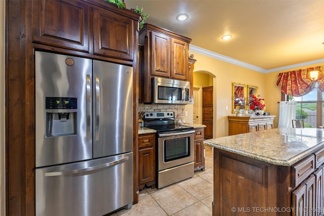 800 Magnolia, Ada, OK 74820 - kitchen featuring stainless steel appliances, arched walkways, light tile patterned flooring, crown molding, and light stone countertops