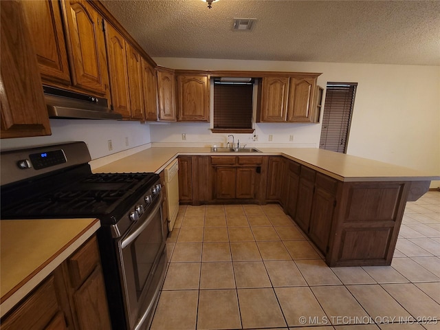 428101 E 1150th Rd, Porum, OK 74455 - kitchen with stainless steel range with gas cooktop, under cabinet range hood, a peninsula, light tile patterned flooring, and white dishwasher