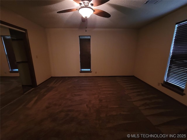 428101 E 1150th Rd, Porum, OK 74455 - spare room featuring ceiling fan, dark carpet, and a textured ceiling