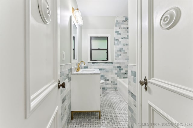 2605 S St Louis Ave, Tulsa, OK 74114 - bathroom featuring vanity, tile walls, tile patterned floors, and a wainscoted wall