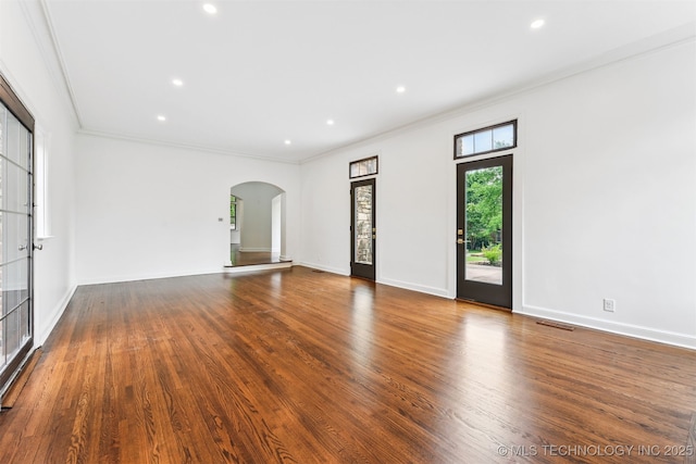 2605 S St Louis Ave, Tulsa, OK 74114 - unfurnished living room featuring arched walkways, wood finished floors, ornamental molding, and recessed lighting