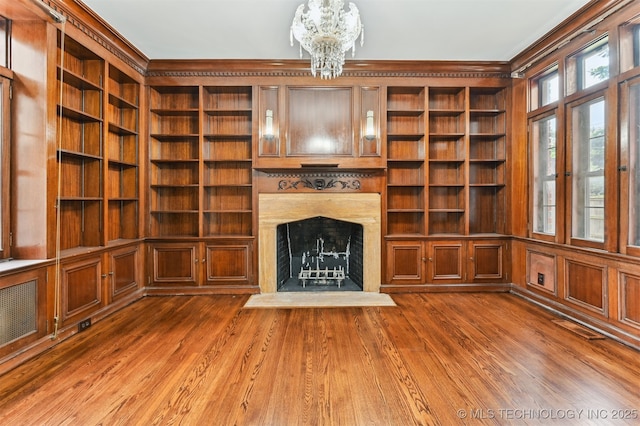 2605 S St Louis Ave, Tulsa, OK 74114 - unfurnished living room featuring ornamental molding, built in features, a chandelier, a premium fireplace, and wood finished floors