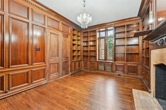 2605 S St Louis Ave, Tulsa, OK 74114 - unfurnished office with a chandelier, built in features, wood finished floors, ornamental molding, and a high end fireplace