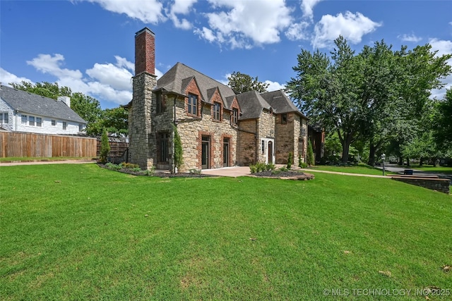 2605 S St Louis Ave, Tulsa, OK 74114 - rear view of house featuring stone siding and a chimney