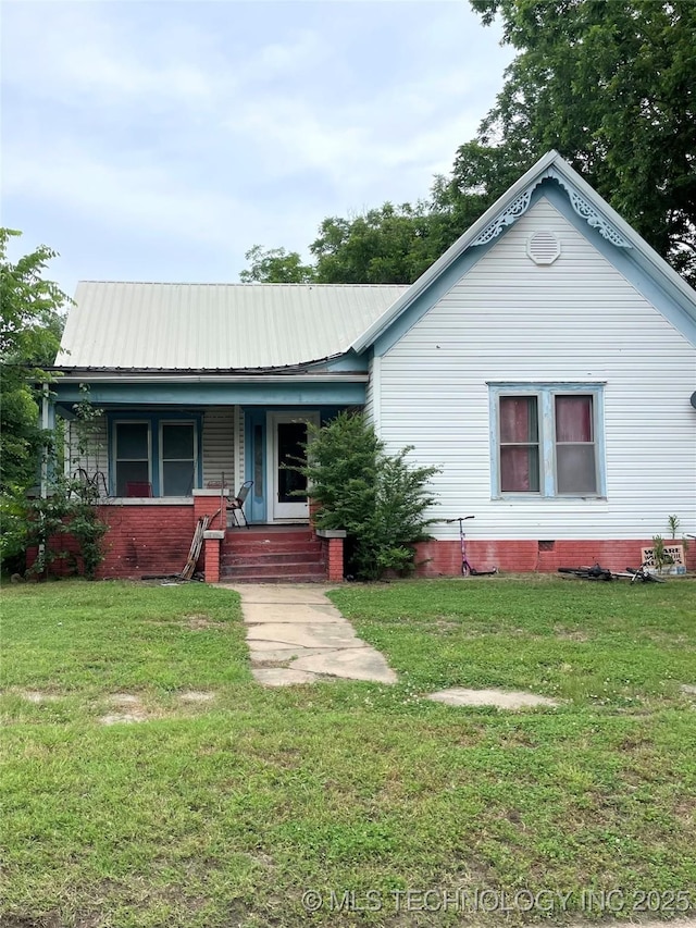 403 E 6th St, Pawhuska, OK 74056 - view of front of property with covered porch, a front yard, and a metal roof