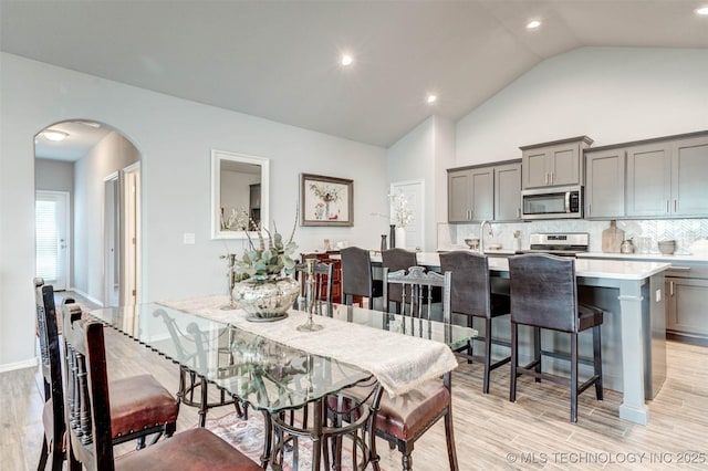 1914 W Imperial St, Broken Arrow, OK 74011 - dining space with arched walkways, light wood-type flooring, lofted ceiling, and recessed lighting