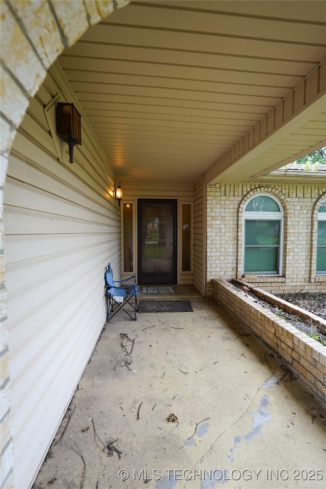 2613 Turner St, Muskogee, OK 74403 - view of exterior entry featuring brick siding and a carport
