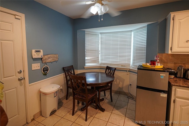 2613 Turner St, Muskogee, OK 74403 - dining room with a ceiling fan, light tile patterned flooring, and a wainscoted wall