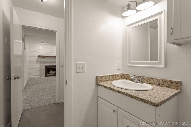 5117 S Lions Ave, Broken Arrow, OK 74011 - bathroom featuring vanity, tile patterned flooring, a fireplace, and a textured wall