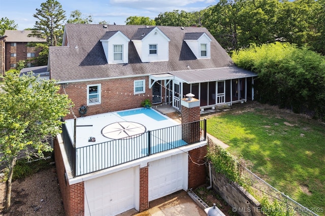 1210 E 15th St, Ada, OK 74820 - rear view of house featuring brick siding, a sunroom, a garage, and a shingled roof
