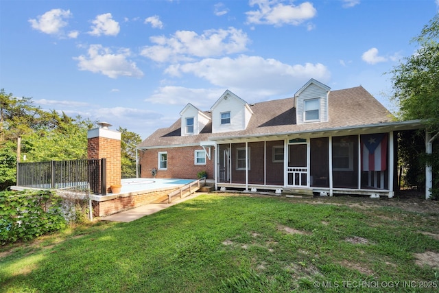 1210 E 15th St, Ada, OK 74820 - rear view of property with a sunroom, brick siding, and a lawn