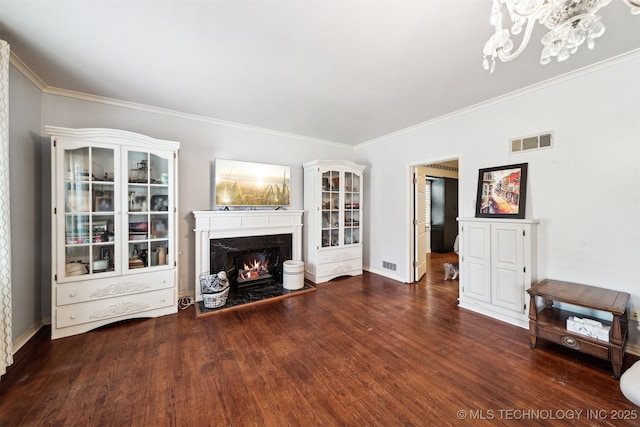 1210 E 15th St, Ada, OK 74820 - unfurnished living room featuring a warm lit fireplace, ornamental molding, wood finished floors, and a chandelier