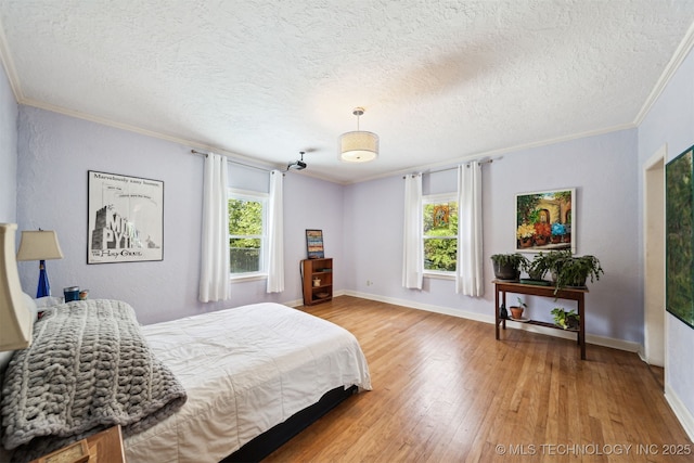 1210 E 15th St, Ada, OK 74820 - bedroom featuring multiple windows, crown molding, wood finished floors, and a textured ceiling