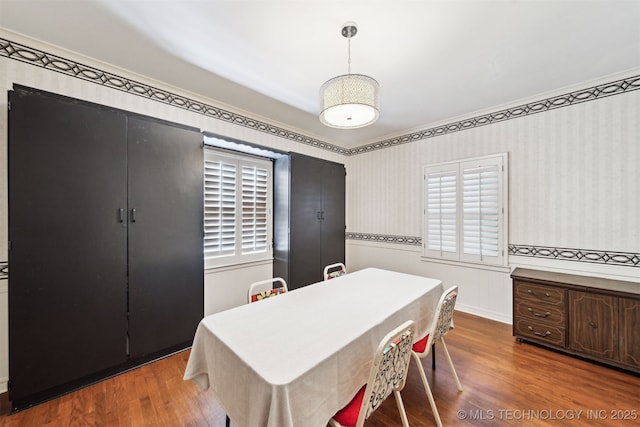 1210 E 15th St, Ada, OK 74820 - dining space with wood finished floors and wallpapered walls