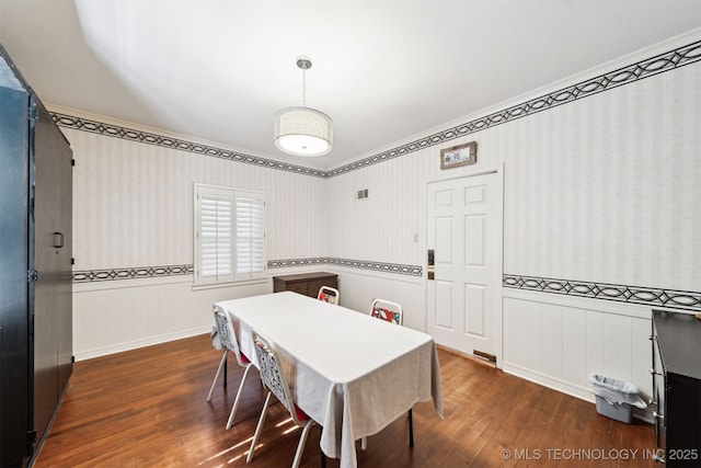 1210 E 15th St, Ada, OK 74820 - dining area featuring dark wood-style floors, ornamental molding, wainscoting, and wallpapered walls