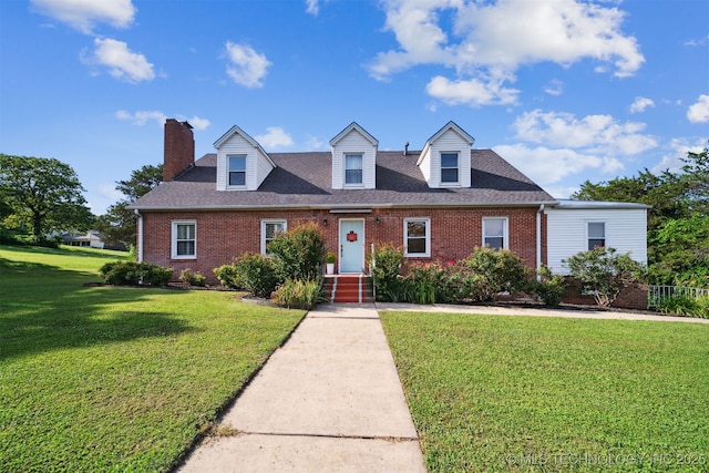 1210 E 15th St, Ada, OK 74820 - new england style home featuring brick siding, a front yard, and a chimney