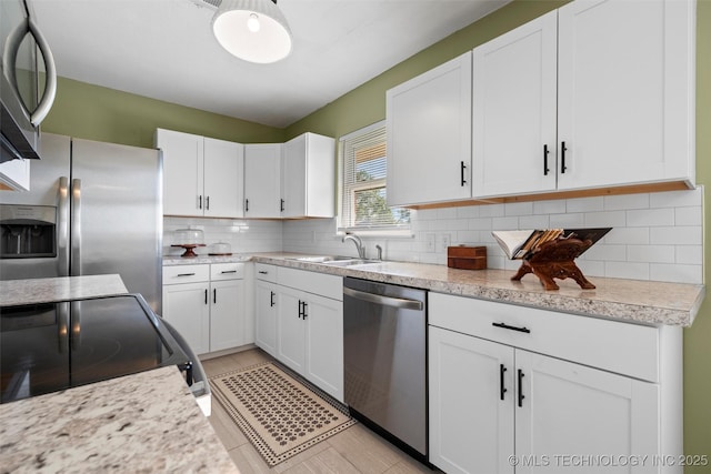 321 NE Elmhurst Ave, Bartlesville, OK 74006 - kitchen with appliances with stainless steel finishes, white cabinets, and backsplash