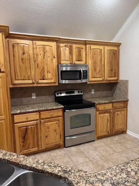 9 Arrowhead, Burneyville, OK 73430 - kitchen featuring stainless steel appliances, crown molding, backsplash, a textured ceiling, and brown cabinets