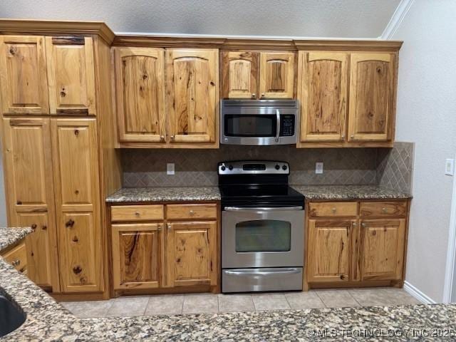9 Arrowhead, Burneyville, OK 73430 - kitchen featuring stainless steel appliances, stone countertops, backsplash, and light tile patterned flooring