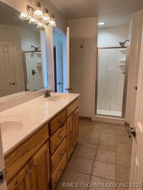 9 Arrowhead, Burneyville, OK 73430 - bathroom featuring a shower stall, double vanity, tile patterned floors, and a chandelier