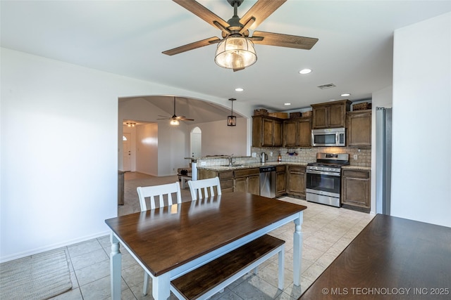 11042 N 120th Ave E, Owasso, OK 74055 - dining space with ceiling fan, arched walkways, recessed lighting, and light tile patterned flooring
