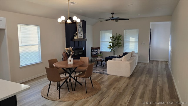 217 E Virgin St, Tulsa, OK 74106 - dining space featuring light wood-style flooring, a large fireplace, ceiling fan, a chandelier, and lofted ceiling