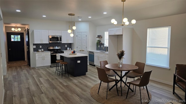 217 E Virgin St, Tulsa, OK 74106 - kitchen featuring stainless steel appliances, a chandelier, backsplash, recessed lighting, and lofted ceiling