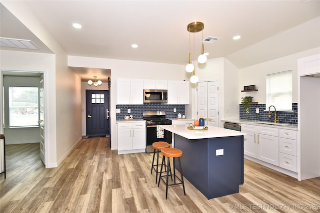 217 E Virgin St, Tulsa, OK 74106 - kitchen featuring stainless steel appliances, light countertops, tasteful backsplash, white cabinets, and lofted ceiling