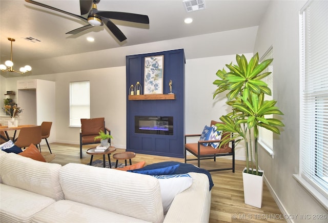 217 E Virgin St, Tulsa, OK 74106 - living area featuring light wood finished floors, a glass covered fireplace, a chandelier, a ceiling fan, and recessed lighting