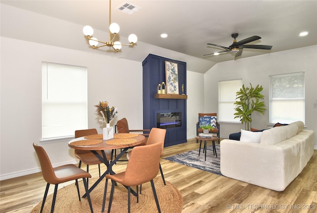 217 E Virgin St, Tulsa, OK 74106 - dining space with a fireplace, a chandelier, light wood finished floors, vaulted ceiling, and ceiling fan