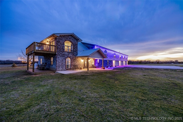 1522 Burney Cemetary, Calera, OK 74730 - back of property at dusk featuring a yard, brick siding, concrete driveway, a patio area, and stone siding
