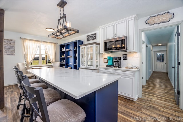 1522 Burney Cemetary, Calera, OK 74730 - kitchen with stainless steel microwave, dark wood finished floors, white cabinets, a kitchen island, and light countertops
