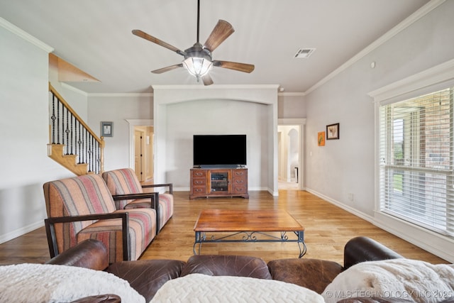8483 N 68th E Ave, Owasso, OK 74055 - living room with a ceiling fan, wood finished floors, ornamental molding, stairs, and arched walkways