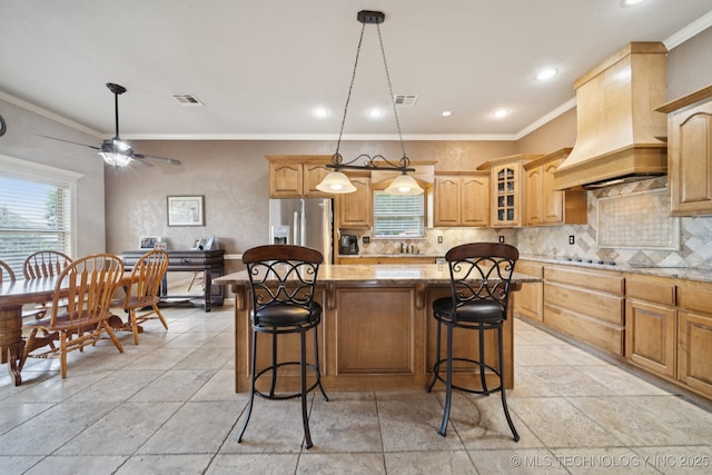 8483 N 68th E Ave, Owasso, OK 74055 - kitchen featuring custom range hood, stainless steel fridge, a center island, light stone countertops, and backsplash