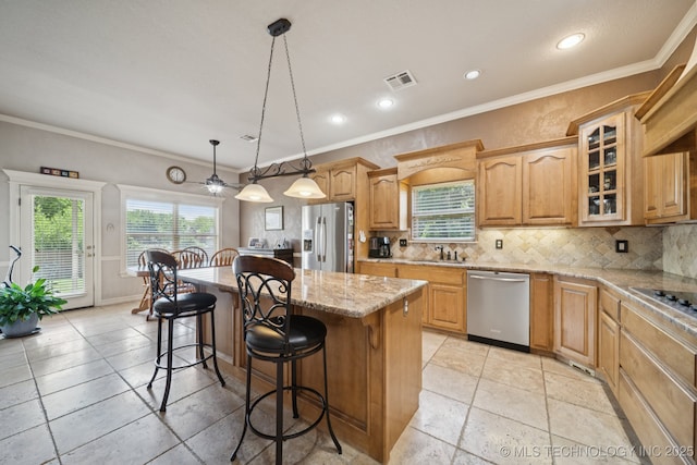 8483 N 68th E Ave, Owasso, OK 74055 - kitchen with appliances with stainless steel finishes, a kitchen bar, a kitchen island, tasteful backsplash, and plenty of natural light