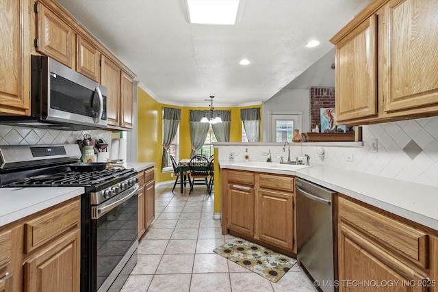 1720 S Juniper Ave, Broken Arrow, OK 74012 - kitchen with stainless steel appliances, decorative backsplash, a chandelier, light countertops, and a peninsula