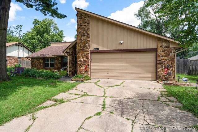 2528 W Commercial St, Broken Arrow, OK 74012 - mid-century modern home with stone siding, concrete driveway, and an attached garage