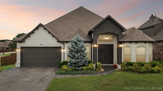 905 W Elmira St, Broken Arrow, OK 74012 - french country home featuring concrete driveway, a garage, a front yard, roof with shingles, and stucco siding