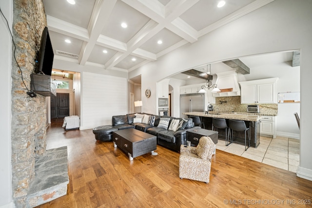 905 W Elmira St, Broken Arrow, OK 74012 - living area featuring beamed ceiling, arched walkways, light wood-type flooring, coffered ceiling, and recessed lighting
