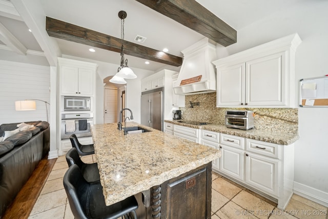 905 W Elmira St, Broken Arrow, OK 74012 - kitchen featuring built in appliances, custom range hood, tasteful backsplash, beamed ceiling, and white cabinets