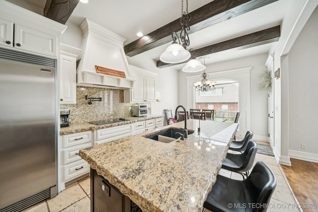 905 W Elmira St, Broken Arrow, OK 74012 - kitchen featuring built in fridge, backsplash, white cabinets, a chandelier, and beam ceiling