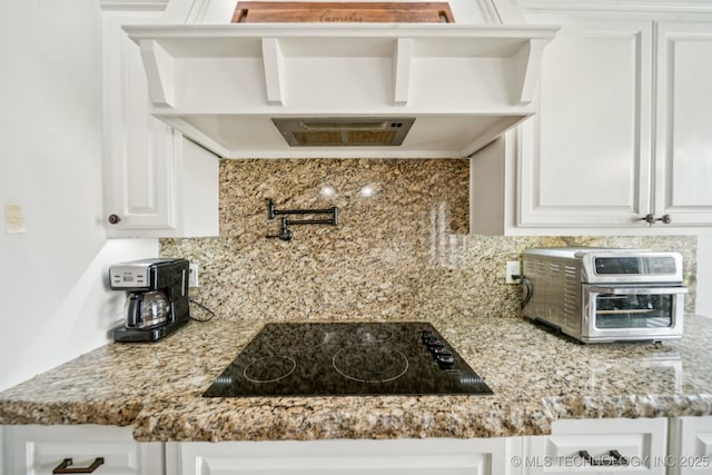 905 W Elmira St, Broken Arrow, OK 74012 - kitchen with black electric stovetop, tasteful backsplash, white cabinets, and wall chimney exhaust hood