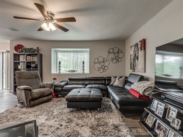 4640 E 68th St Unit 285, Tulsa, OK 74136 - living room featuring wood finished floors, a ceiling fan, and a textured ceiling